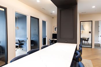 A conference room with a long table and chairs.